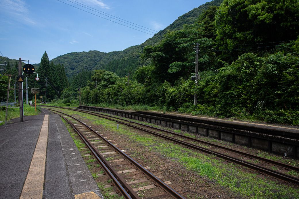 青い空、緑濃い森、駅のホーム。これぞ夏の田舎といった旅情を感じる（筆者撮影）