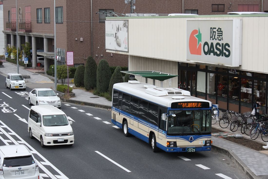 阪急系のスーパーマーケットの前にあるバス停に阪神バスが停車。ちょっと違和感のある光景だ（筆者撮影）