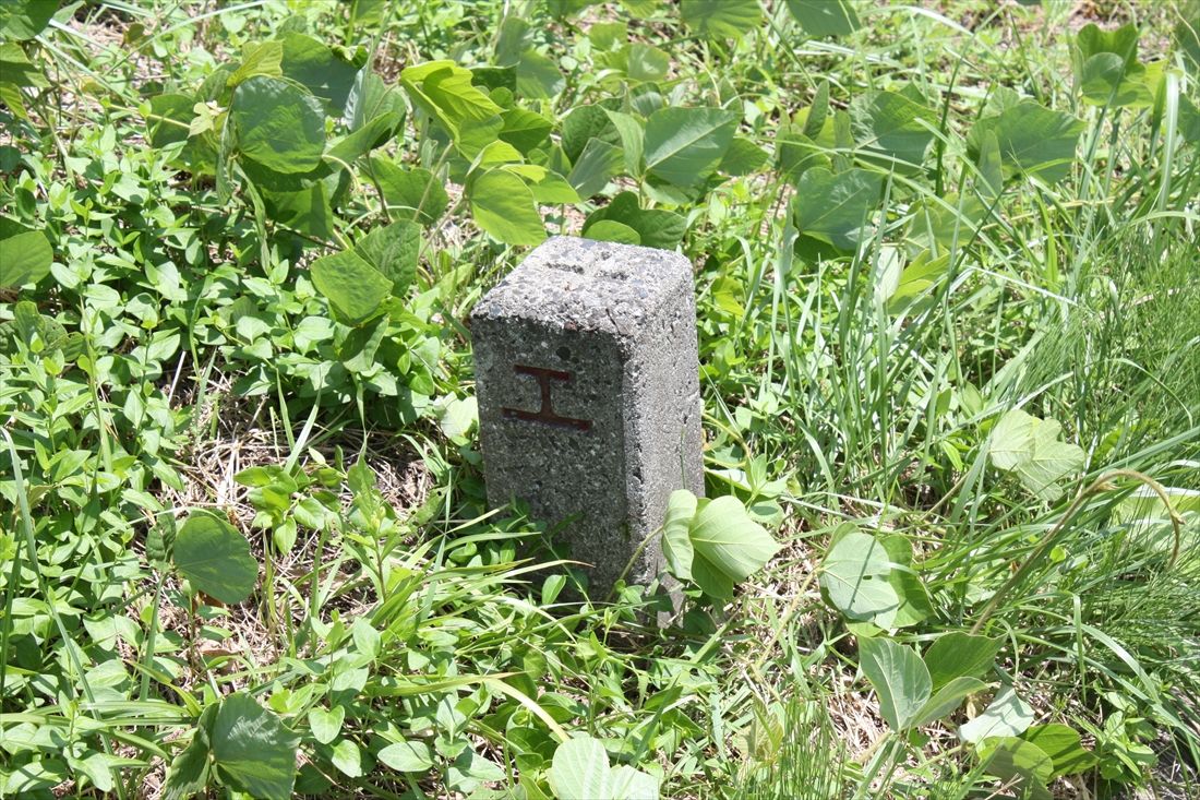 （新線）旭町駅は現在の浜田市旭町の旭中学校付近に設けられる予定だった。中学校南側の交差点近くに国鉄や鉄道公団が使用していた「工」の字の土地境界標が残る（筆者撮影）