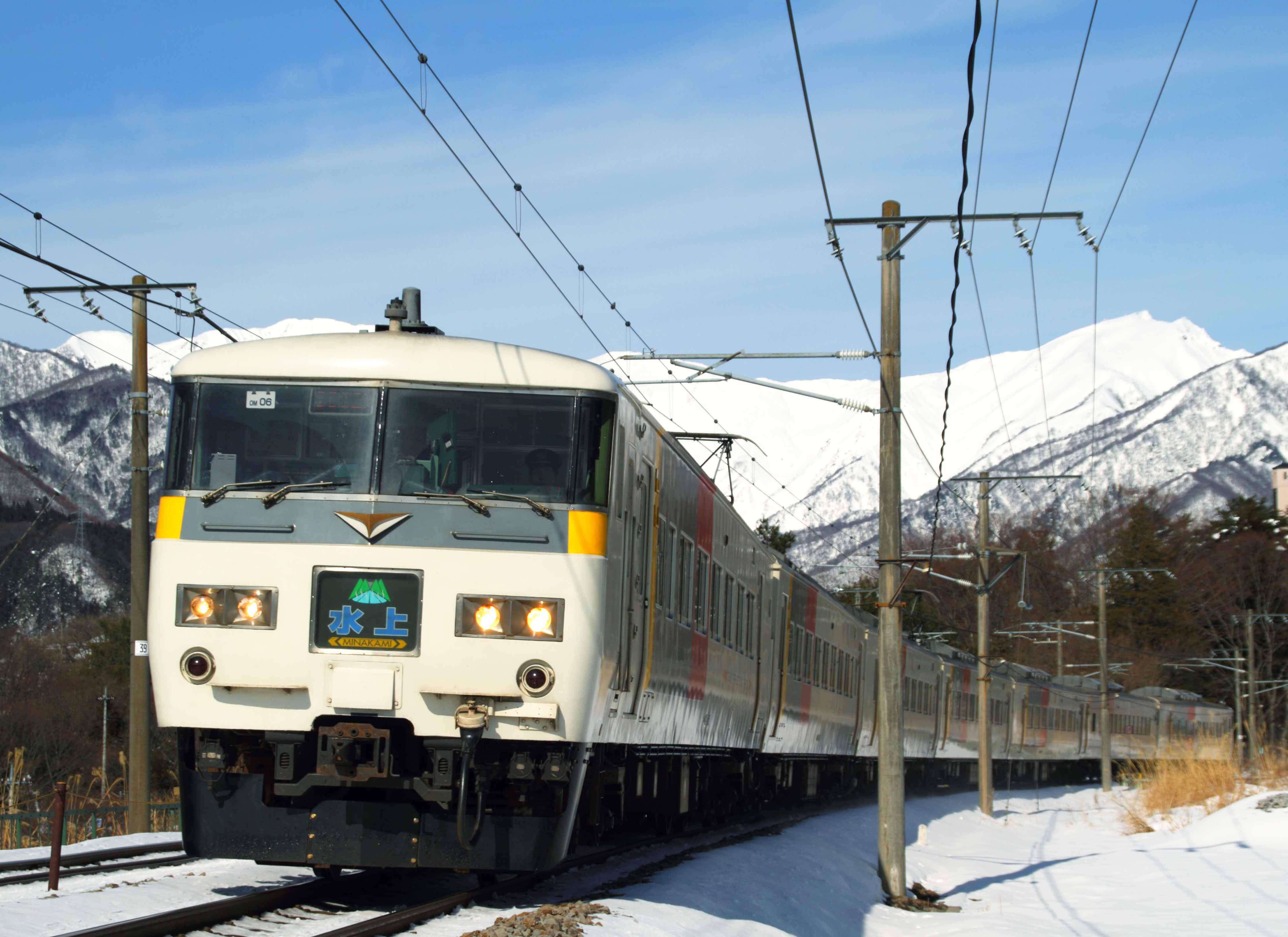 冠雪した谷川岳をバックに走る特急「水上」（撮影：南正時）