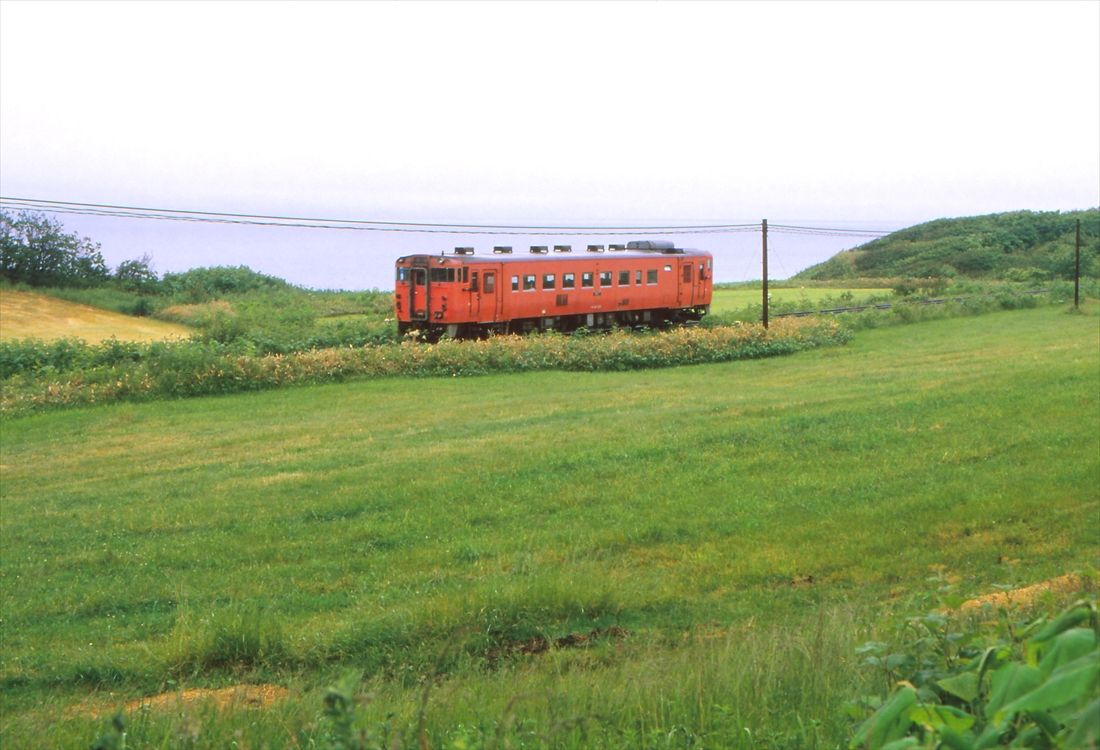 オホーツク海をバックに走る興浜北線の列車＝1983年6月（撮影：南正時）