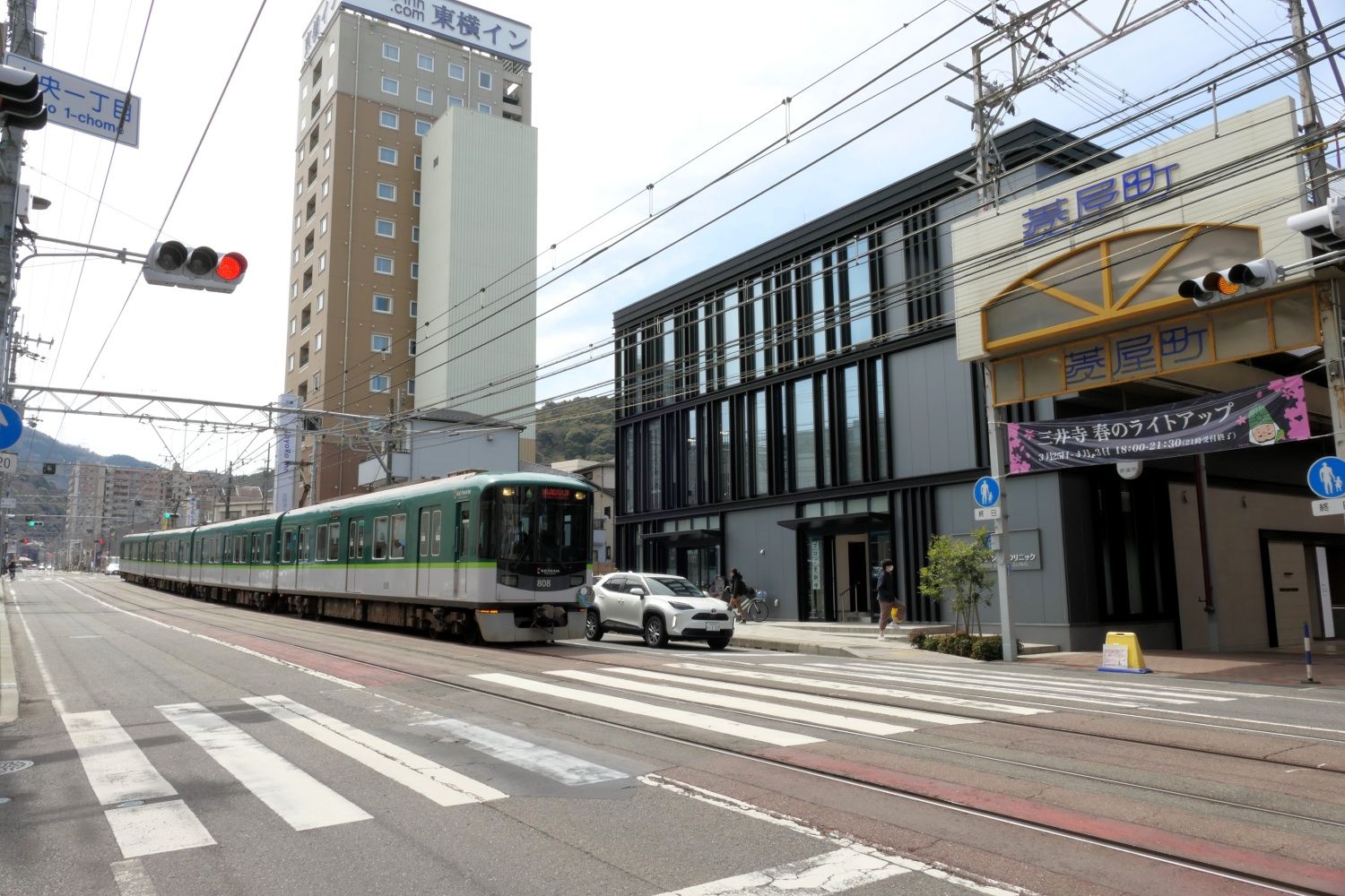 横断歩道の手前で自動車と並んで信号待ち（記者撮影）