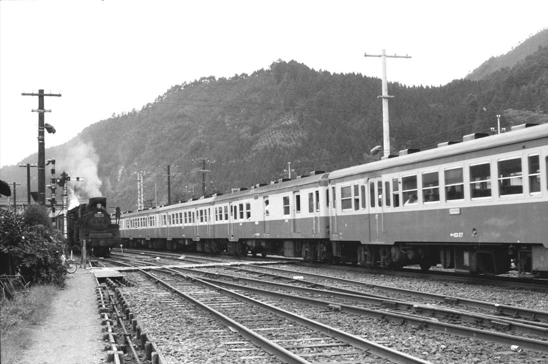 播但線生野駅にて、さまざまな形式の気動車を連ねた列車とC57形牽引の列車が行き違う（撮影：南正時）