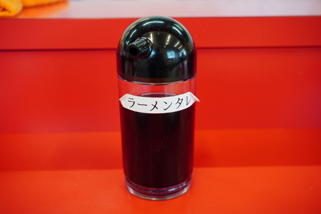 テーブルには「ラーメンタレ」も置いてあり、スープの味を濃くしたいときに自由に入れられるようになっている。もやしたっぷりの優しい味をちょいと濃いめにするのも大いにアリだ！（筆者撮影）