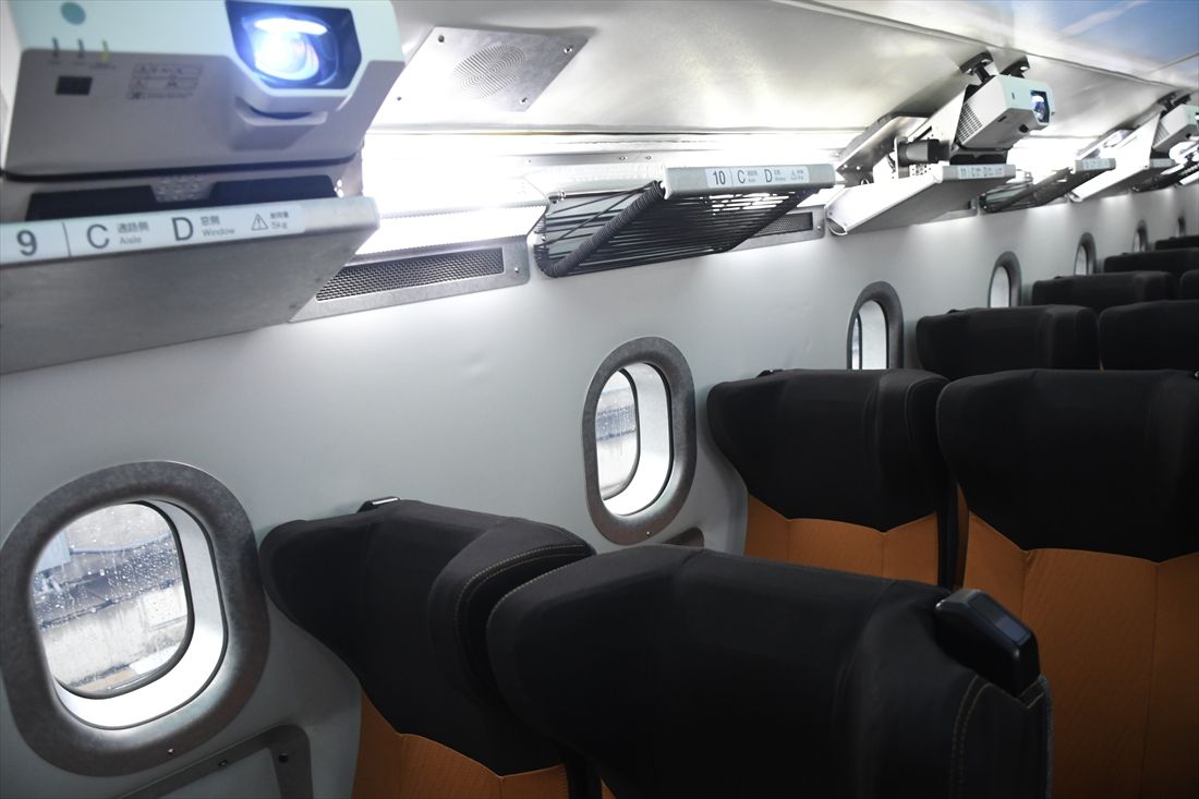 M10の座席上荷棚付近には天井に映像を映し出すプロジェクターが並ぶ（記者撮影）