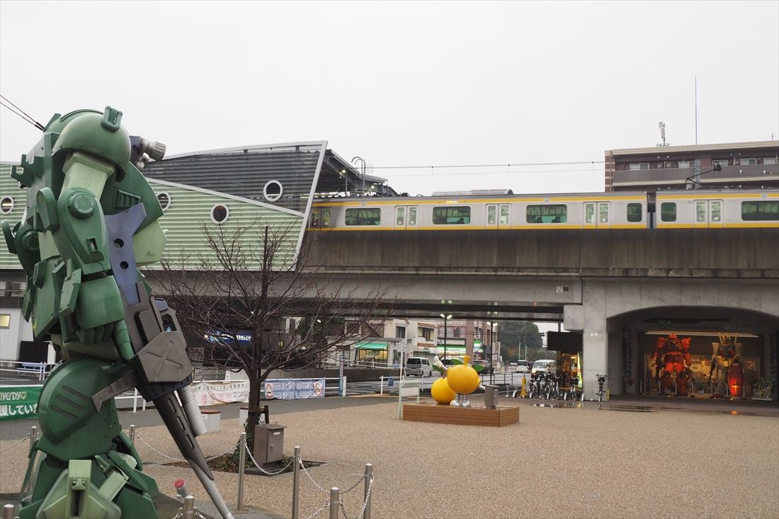 高架化された稲城長沼駅付近を走る南武線。駅近くには稲城市在住のメカニックデザイナー大河原邦男氏がデザインした、アニメ「装甲騎兵ボトムズ」に登場する「スコープドッグ」のモニュメントがある（編集部撮影）