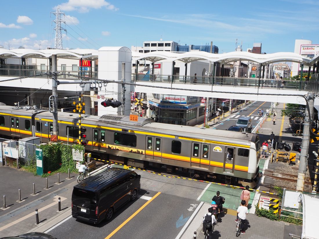 鹿島田駅前の踏切を通過する電車。同駅周辺は歩行者デッキが整備されている（記者撮影）