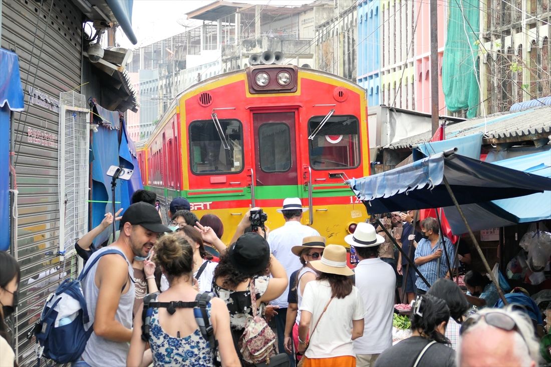 列車が通過するとすぐに軒が降ろされる。同時に線路内も大勢の観光客（筆者撮影）