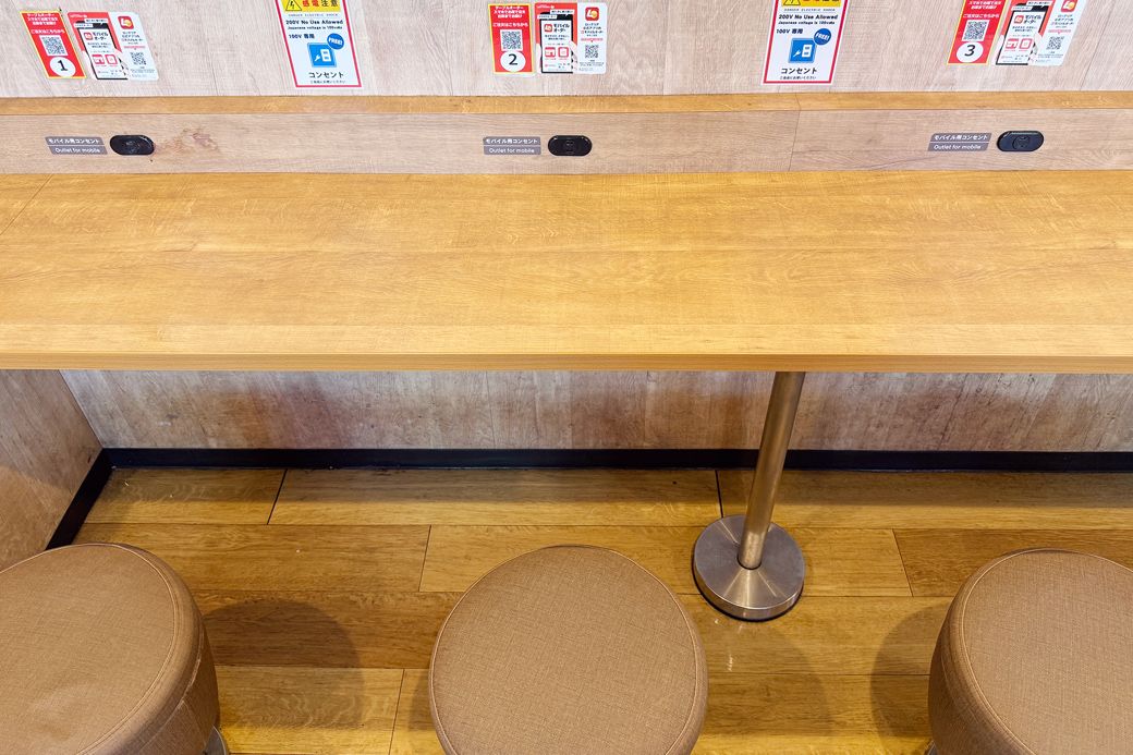 カウンター全席にコンセント付き。コンセントご自由にお使いくださいと書かれたステッカーも貼ってある（写真：筆者撮影）
