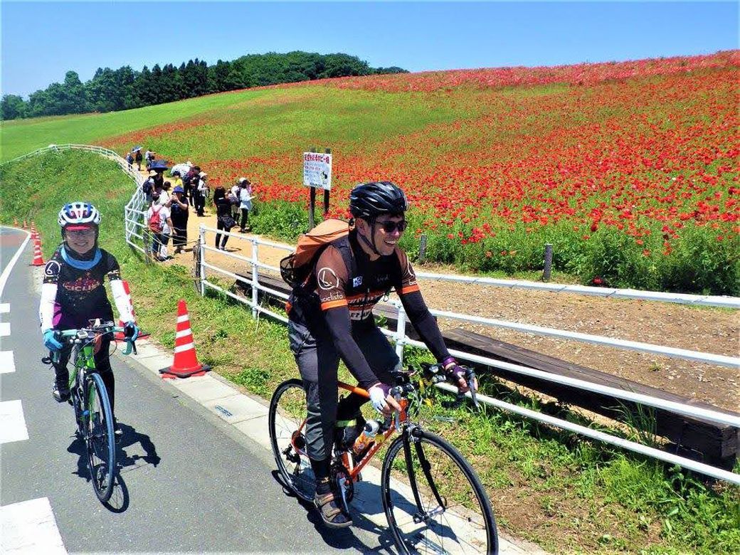 秩父高原牧場の「天空のポピー」の会場脇を走る、2016年の坂田さん夫婦（写真：瀬戸圭祐氏 撮影）