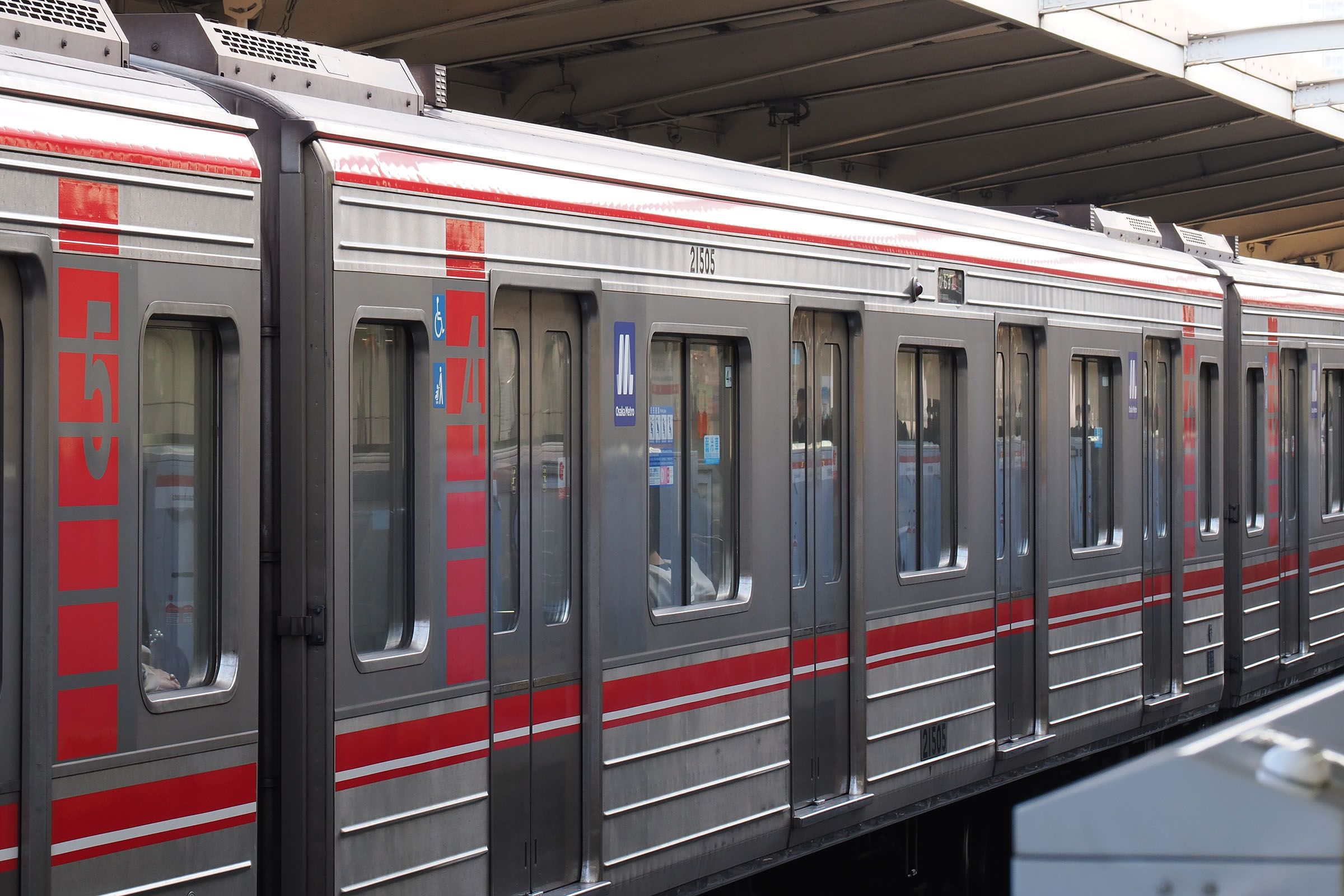 御堂筋線用21系の側面のビード（線状の突起）を見ると車高を下げていない4号車（中央）と下げた3・5号車の高さの違いがわかる（撮影：伊原薫）