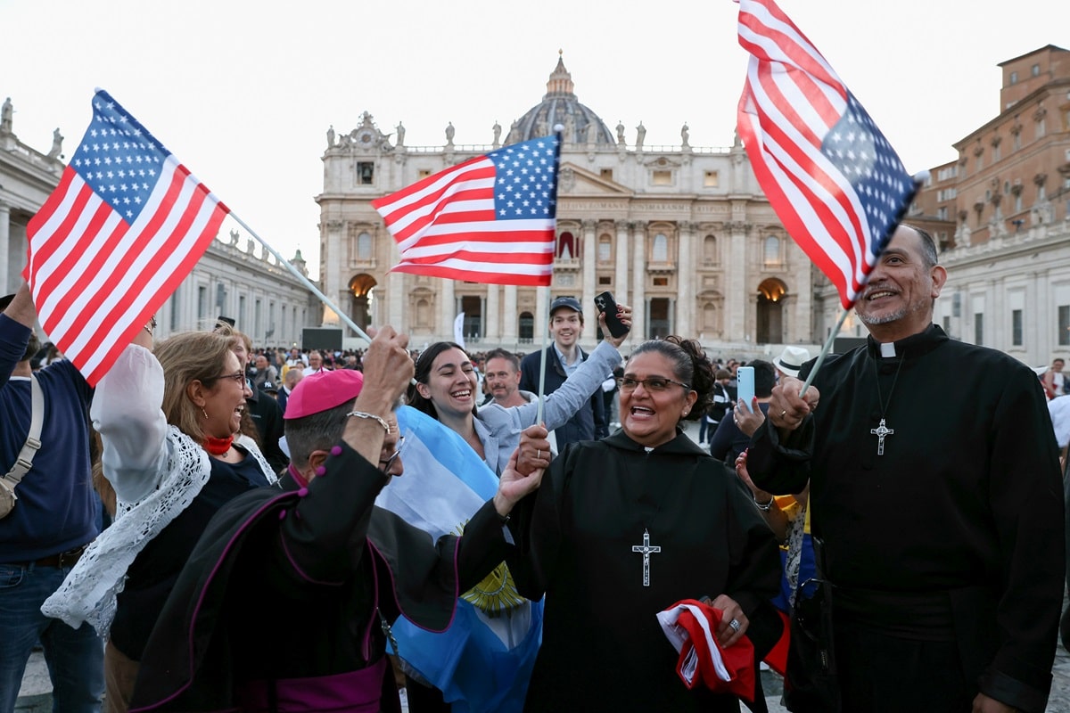 レオ14世の出身国であるアメリカの国旗を掲げる人たち（写真：ブルームバーグ）