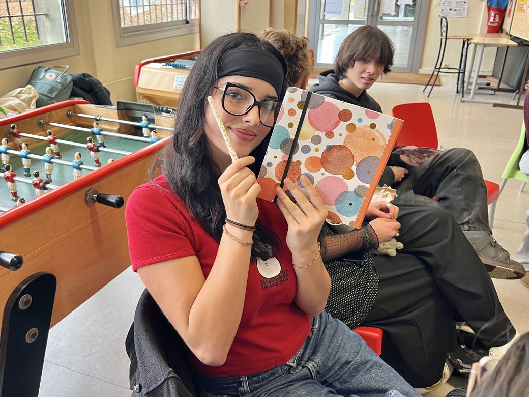 スケッチブックとペンをもらって笑顔を見せる（筆者撮影）