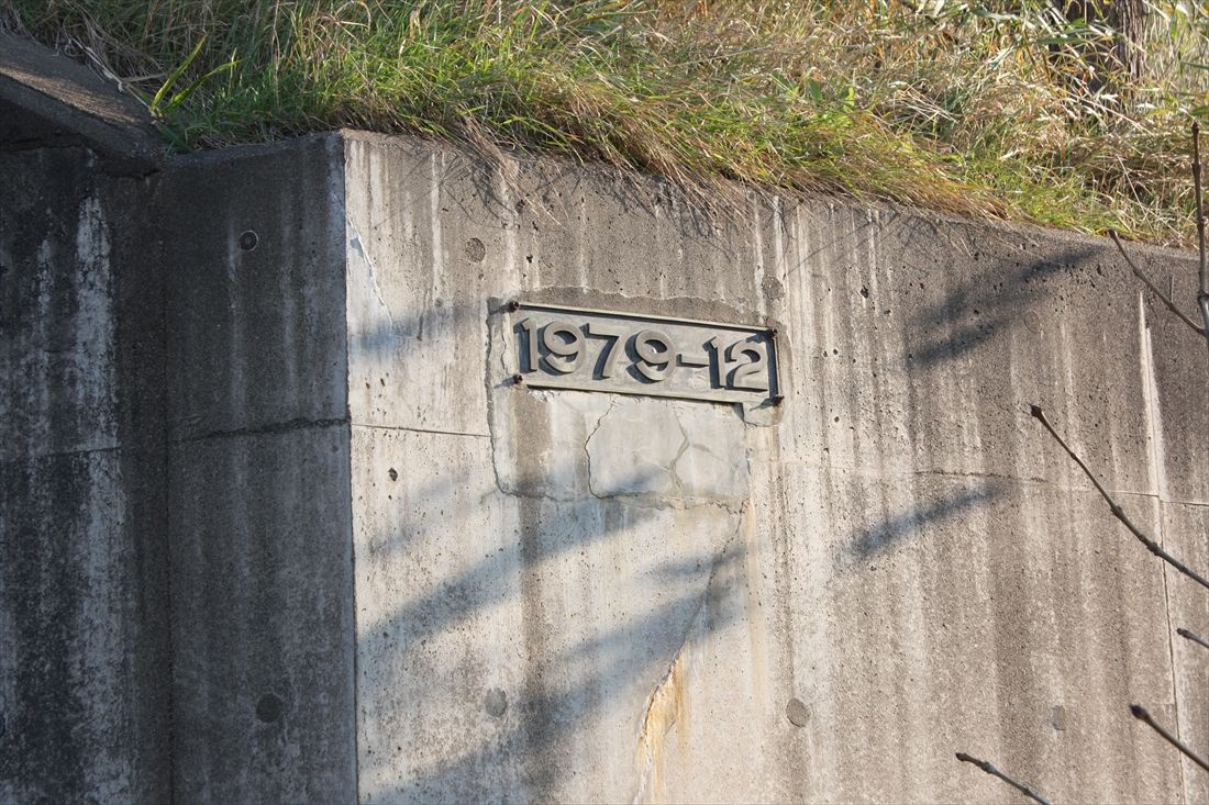 歌登―辺毛内間：美幸線の路盤をまたぐ道路橋のコンクリート擁壁に工事の完了時期を示す「1979-12」の文字。1980年度の予算凍結直前まで工事が行われていたことを示している（筆者撮影）