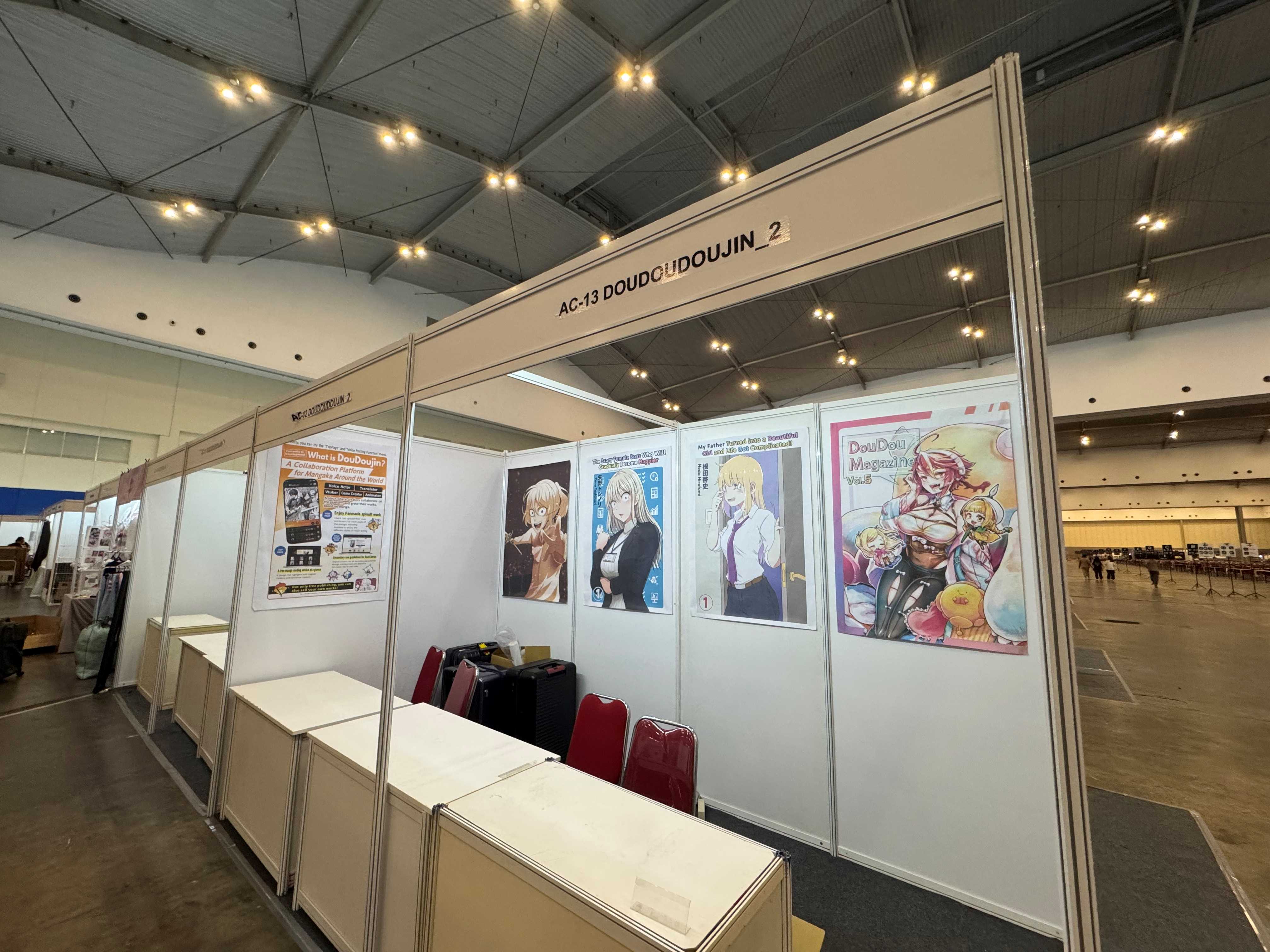 DouDouDoujin サークルスペース。企業・大手向けコーポレートブースの大型スペースを使用し、壁面には各先生の作品ポスターが貼られている(写真:水谷代表提供)