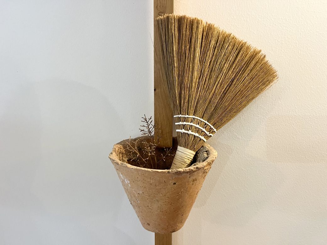 壁に掛けられた日本の小さなホウキ。このように置くと、ホウキもインテリアに馴染む。真似したいアイディアだ（筆者撮影）