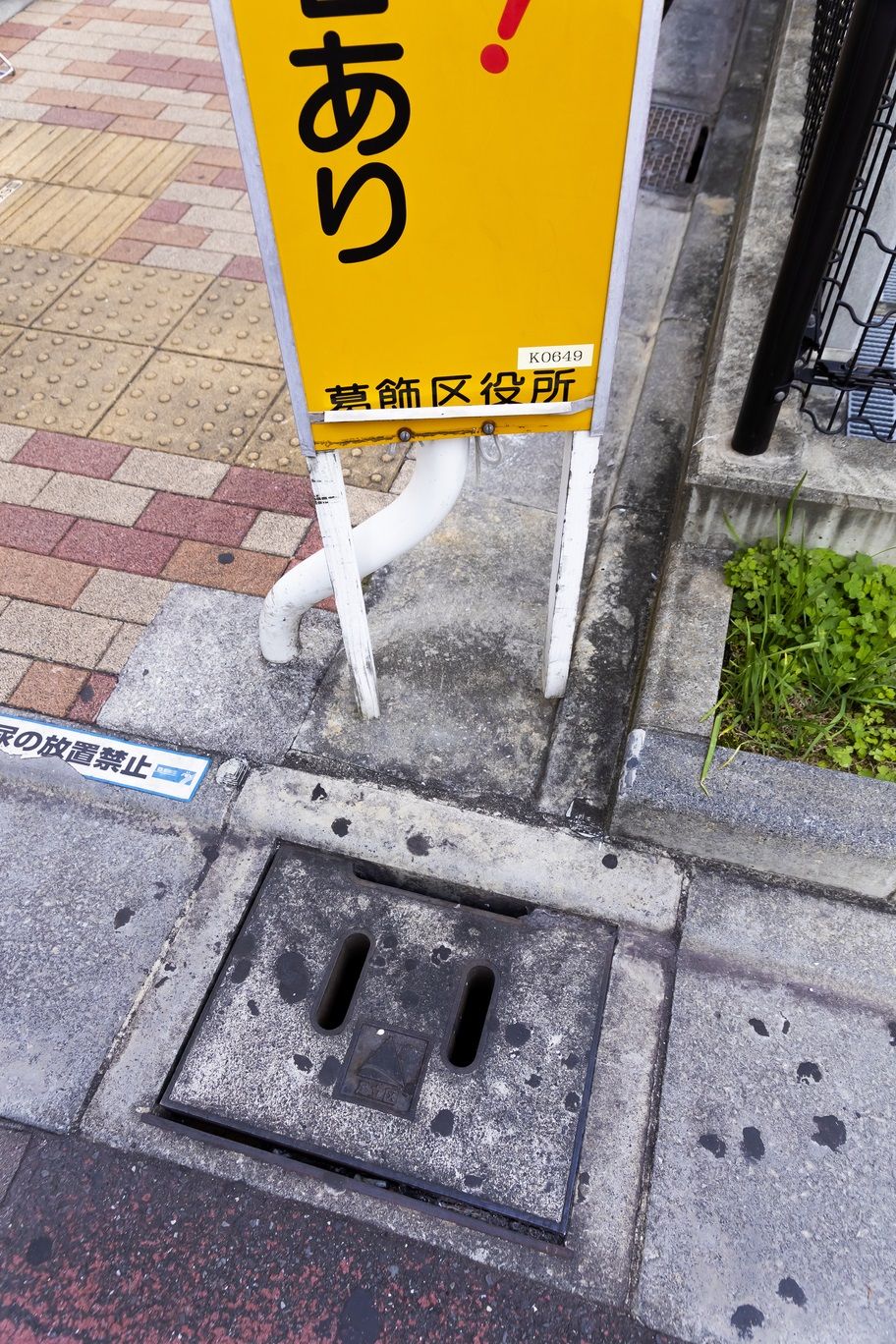 看板は葛飾区、側溝のふたは足立区のもの（撮影：今井 康一）