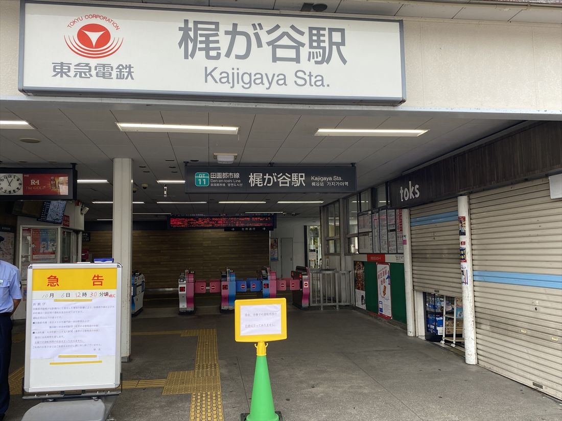 東急田園都市線梶が谷駅には運転見合わせを知らせる看板が立ち、駅員が利用者に代わりのルートなどを案内していた＝2025年10月6日（記者撮影）