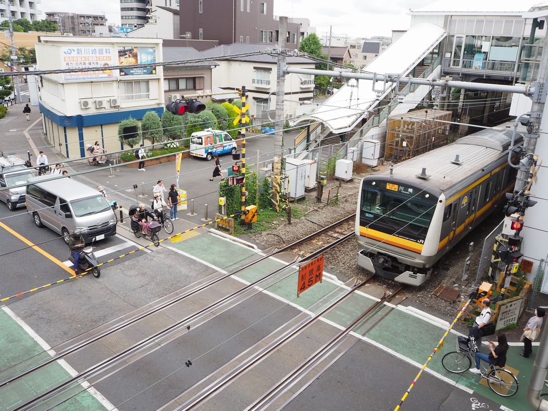 鹿島田駅前の踏切にさしかかる電車（記者撮影）
