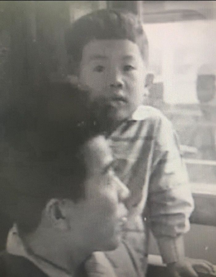 幼少期の江蔵さんと育ての父-（写真提供／江蔵智さん）