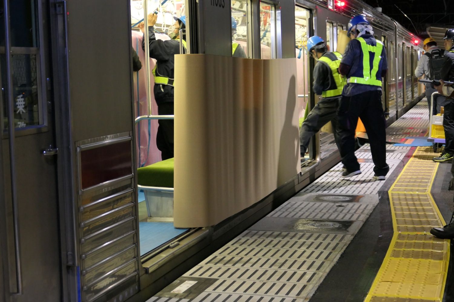 筐体を運び出す前に車両の外側にも養生が施された（記者撮影）