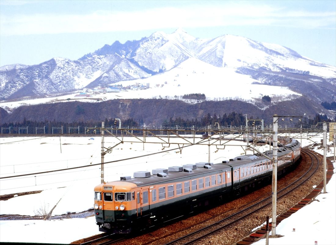 雪景色の中を走る165系の急行「佐渡」（撮影：南正時）