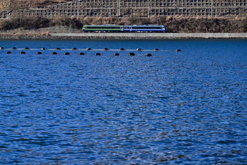 万石浦をゆく、だてSATONO号。女川駅到着前、車窓には輝く海が広が離る。大きな窓のSATONO号からの眺めは一段と格別である（筆者撮影）