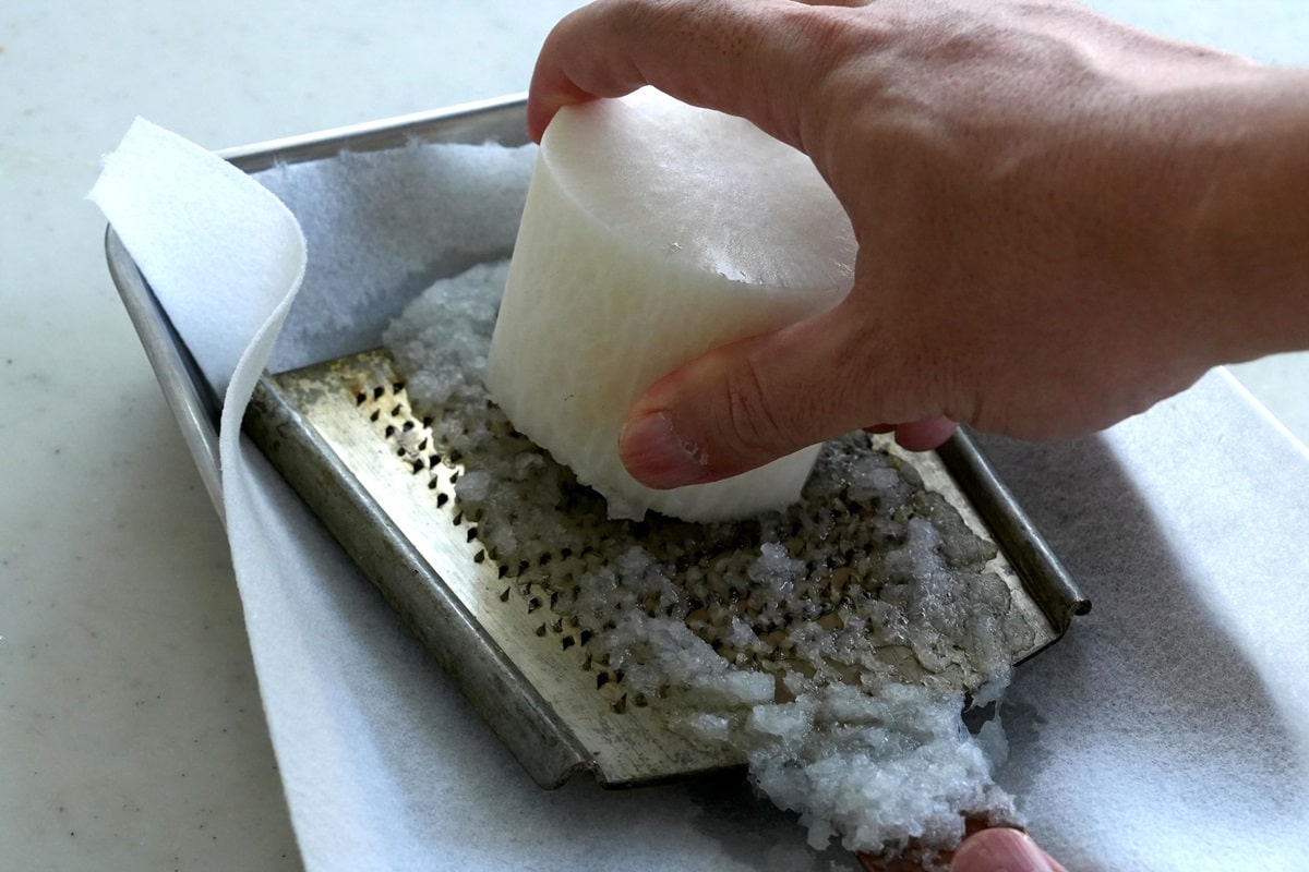 おろし金で大根を下ろすときは滑り止めにさらしやキッチンペーパーなどを敷きます（写真：筆者撮影）
