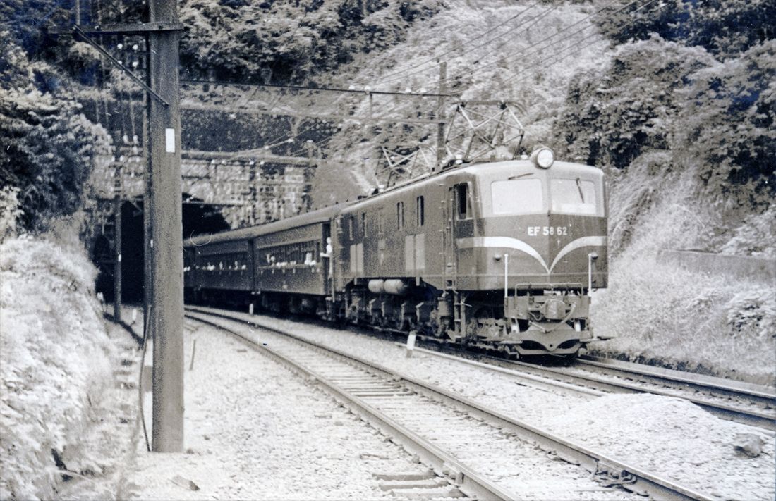 真鶴付近を走るEF58形牽引の列車。前面窓に水切りなどのない原型の姿だ＝1954年（写真：大塚康生）