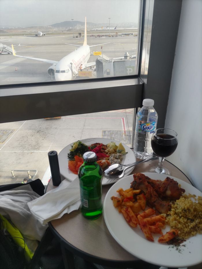 ペットボトル入りの水を提供しているラウンジはかなり多い。異国の水道水はアタルので、ペットボトル入りなら安心。ちなみにワイングラスに入ってるのはコカ・コーラです（筆者撮影）