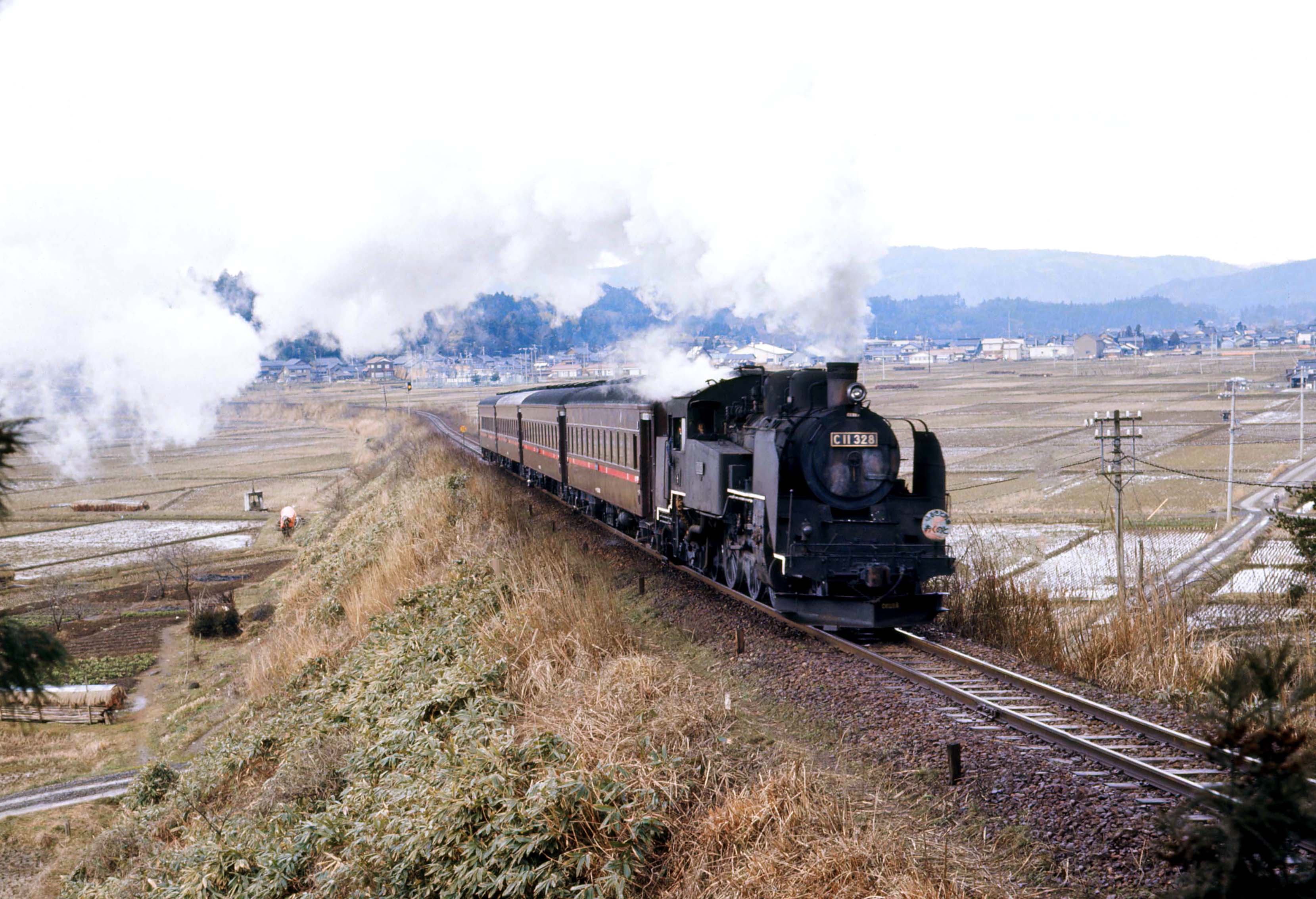 能登中島付近を走るC11形牽引の「ふるさと列車おくのと」号（撮影：南正時）