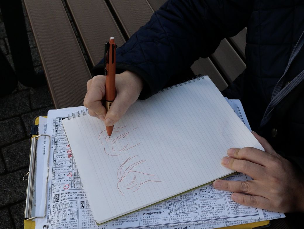 理想的な馬のお尻のイラストを描く志賀さん。その表情はとても生き生きとしていた（筆者撮影）