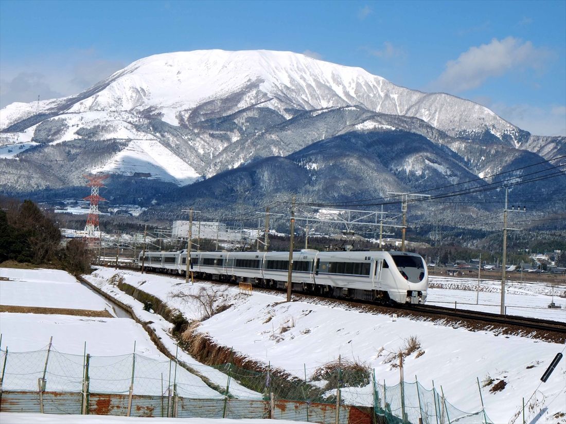 冠雪した伊吹山をバックに雪景色の中を駆け抜ける特急「しらさぎ」（撮影：南正時）