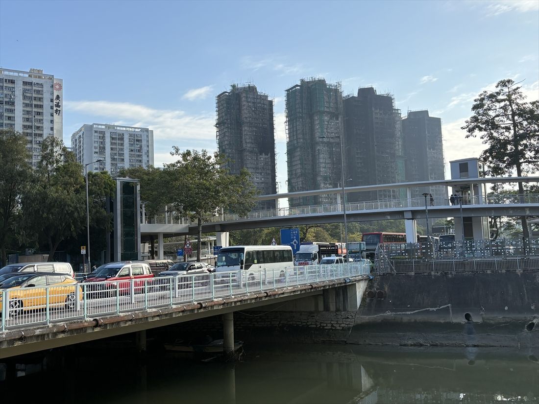 水路と橋梁越しに見る、火災の起きた高層住宅（筆者撮影）