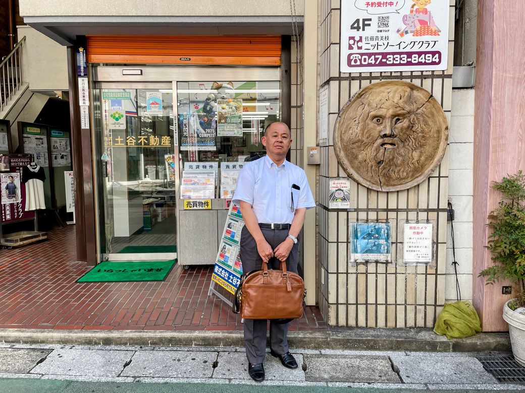 店舗の前で、土谷不動産代表の土谷幸司さん（筆者撮影）