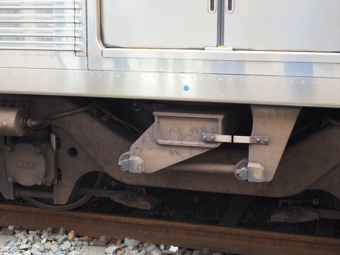 台車部分の車体裾にある小さな青丸はパンタグラフの位置を示している（記者撮影）