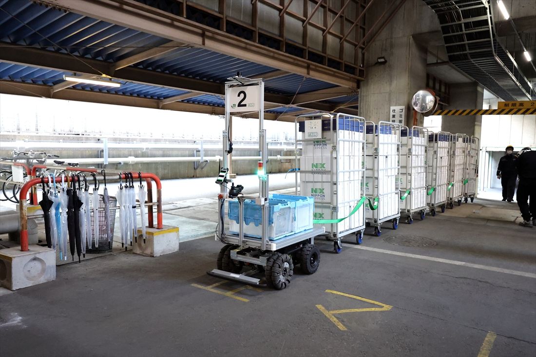 AGVが荷物を載せた台車を牽引する様子は列車のようだ＝2026年3月23日（撮影：尾形文繁）