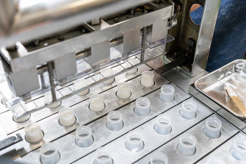 専用機械でプラスティックの瓶にクリームを充填していく（写真：筆者撮影）