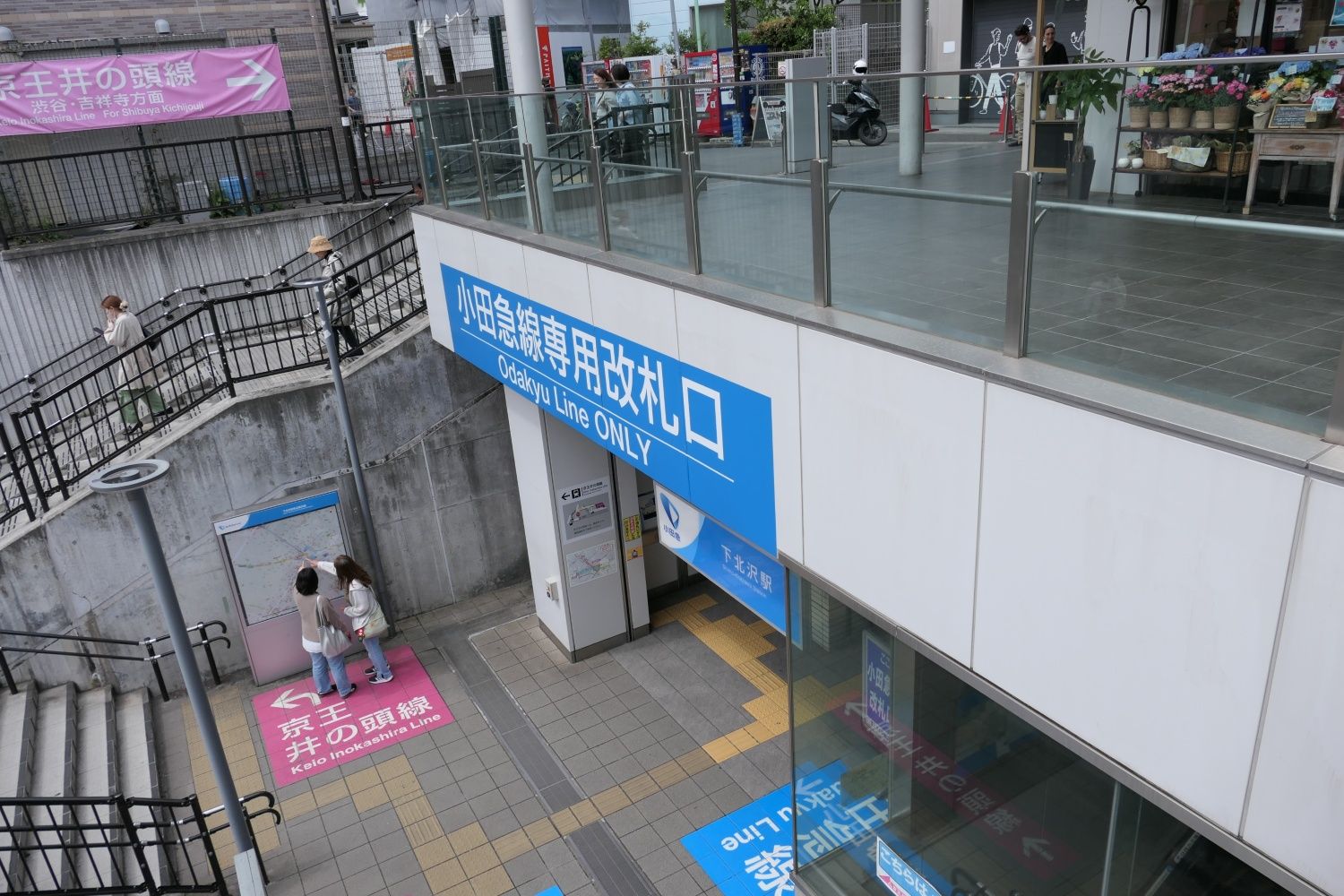 京王井の頭線へはピンク色の案内サインが誘導（記者撮影）