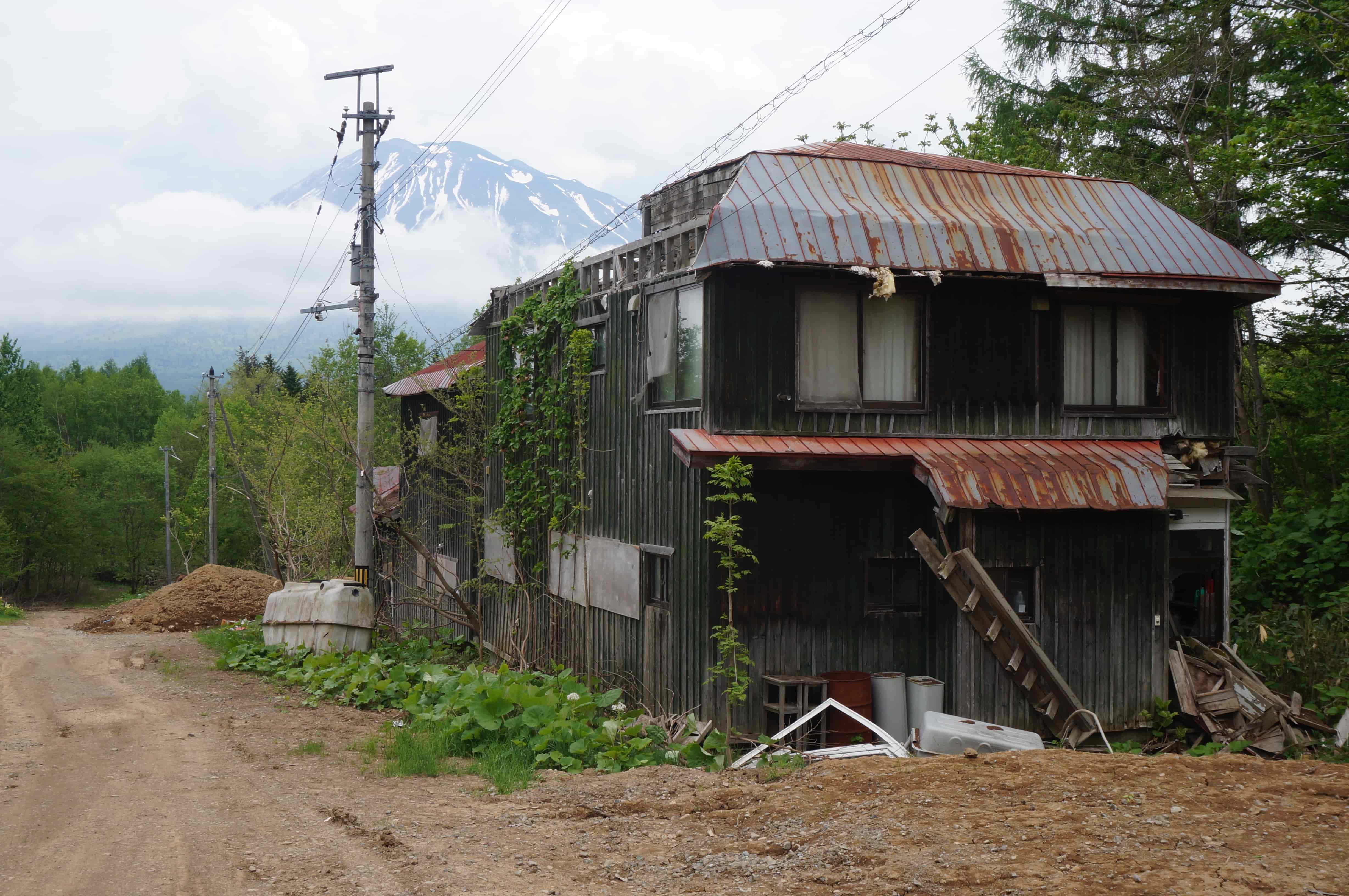 廃屋と羊蹄山。山林を切り開いた場所だが、工事車両が行き交っていた（写真：筆者撮影）