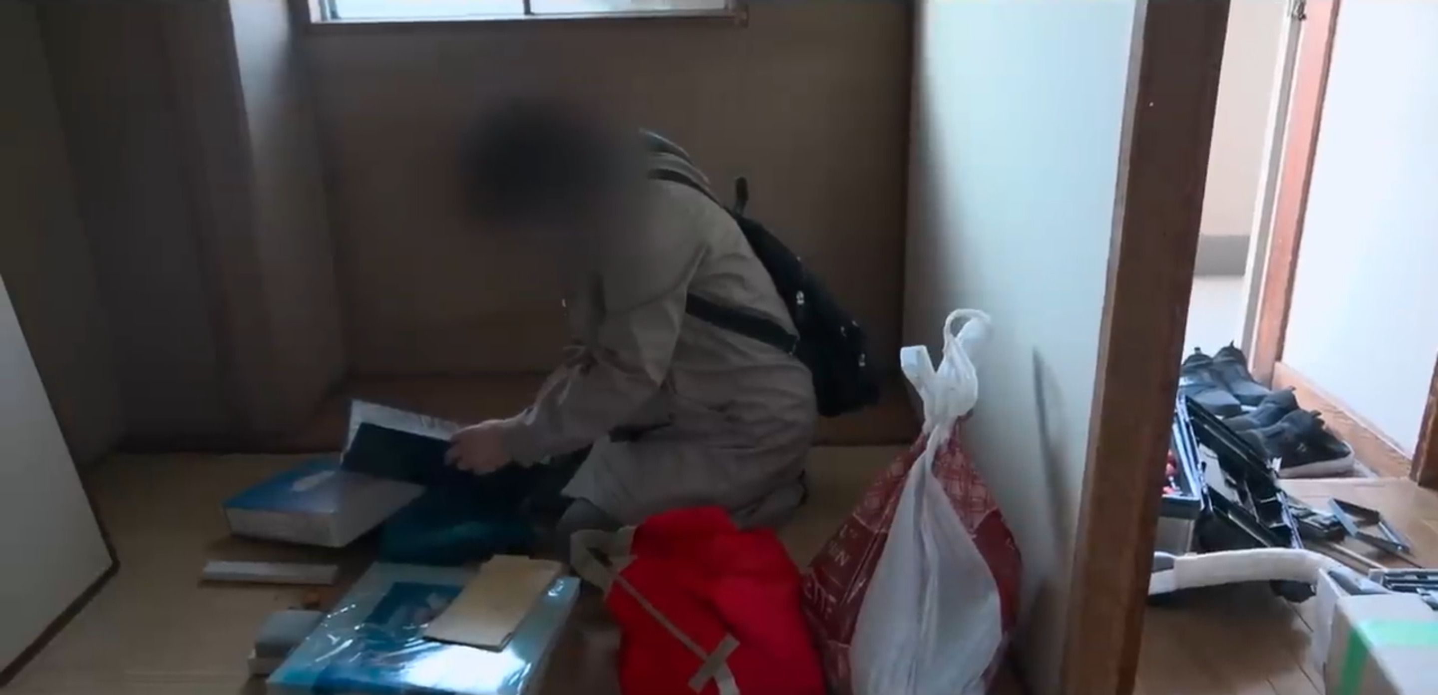 部屋に残されていた重要書類やアルバムを確認する依頼者（写真：「イーブイ片付けチャンネル」より）