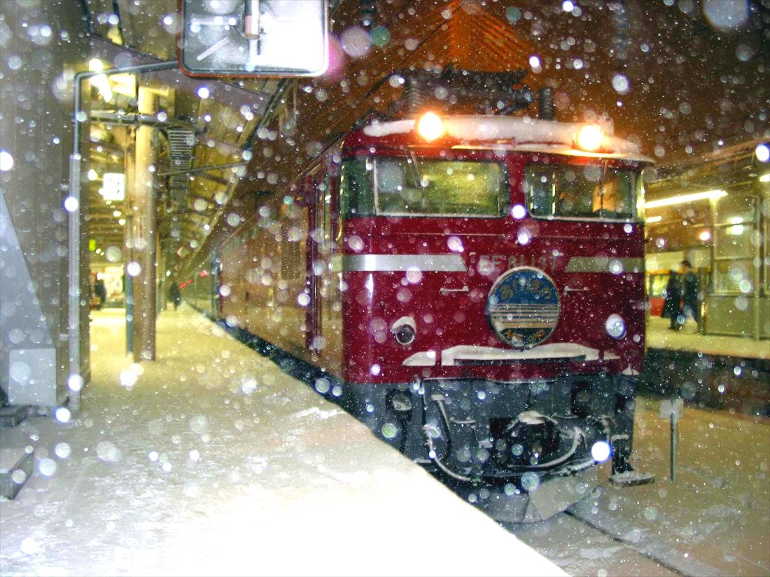 吹雪の青森駅で発車を待つEF81形牽引の寝台特急「あけぼの」（撮影：南正時）
