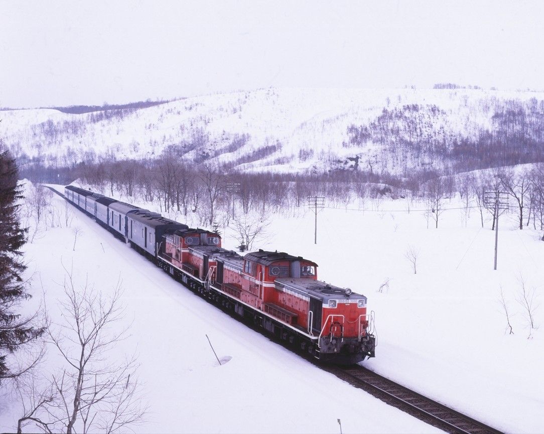 雪景色の函館本線黒松内付近を走るDD51形重連牽引の急行「ニセコ」。前照灯をボンネット上に増設した「三つ目」が先頭に立つ（撮影：南正時）