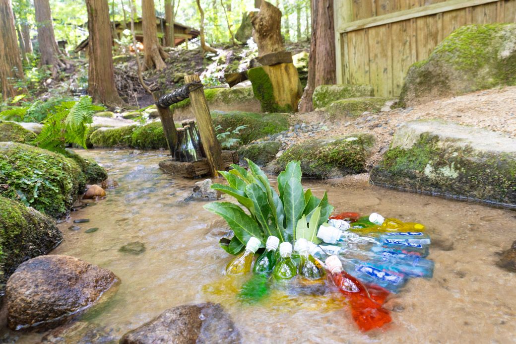 見た目に涼しげな、水辺に瓶ビールやラムネが冷やされている様（筆者撮影）