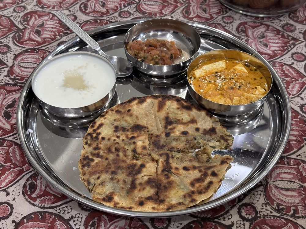 インドの家庭料理、Jさん宅の昼食プレート。アルバラタにはプレーンヨーグルトが添えられている（写真：八木さん提供）