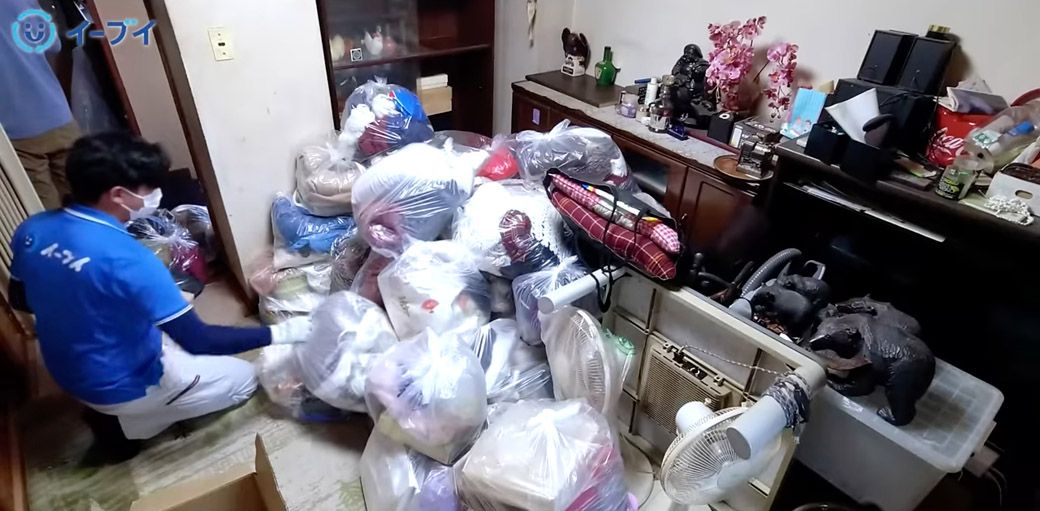 大量の衣類を仕分けるスタッフ（写真：「イーブイ片付けチャンネル」より）