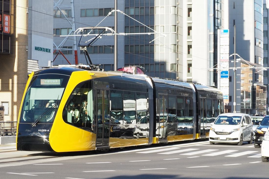 車と並走するLRT＝2023年8月26日（記者撮影）