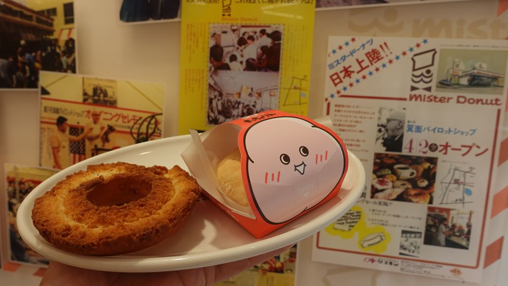 ミスタードーナツの開業当時のチラシと「もっちゅりん」。箕面ショップにて(筆者撮影)