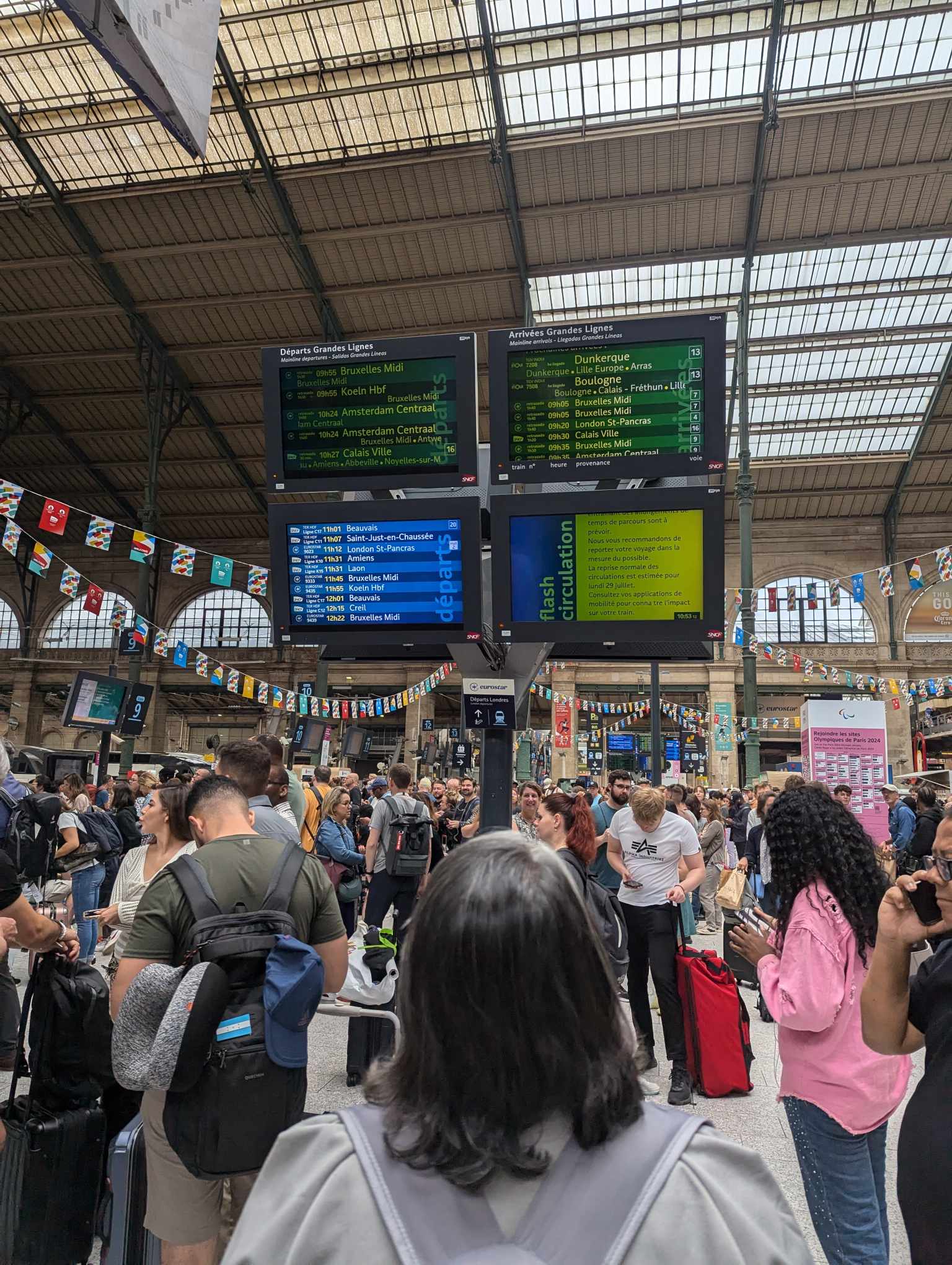 パリ北駅にて、列車の運行状況を示す案内板を見つめる人々＝7月26日（写真：m_sports_suki）