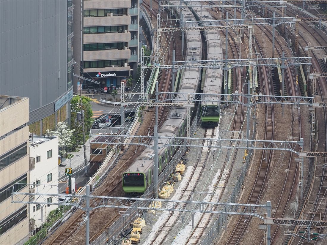 線路切り換え工事前の田町駅付近。線路を移動する部分は工事に備えてバラスト（砕石）を袋詰めにしているため白っぽく見える（記者撮影）